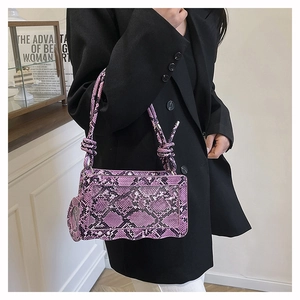 Détail du sac à bandoulière violet à motif serpent avec pendentif cœur et poignée nouée
