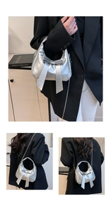 Detail of silver metallic bow-knot handbag with chain strap and shiny PU leather finish