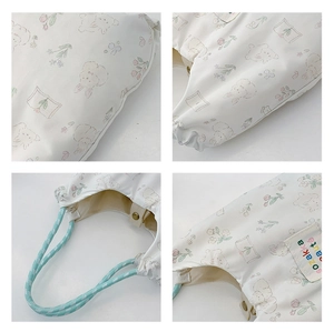 Macro view of nylon tote bag with floral bunny prints and light blue woven handles