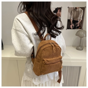 Mini sac à dos en velours côtelé marron porté par un modèle pour un look décontracté