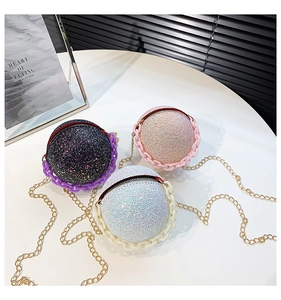 Close-up of sparkling sequin spherical bags with chain straps in purple, pink, and white