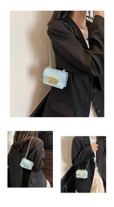 Detail of light blue mini chain bag featuring gold hardware and shiny finish on crossbody strap