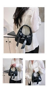 Detailed view of black bow handbag featuring glossy finish and silver chain strap