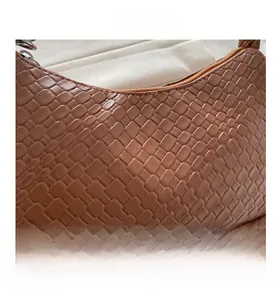 Close-up of the brown embossed crocodile texture and metal zipper on this shoulder bag