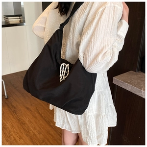 Dettaglio della borsa tote grande in nylon con corda decorativa su modella in bianco