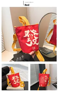 Detail of red canvas bucket bag with yellow straps and Chinese lucky character print