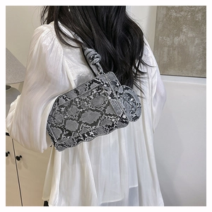 Détail du sac bandoulière serpent avec poignée nouée et design géométrique chic