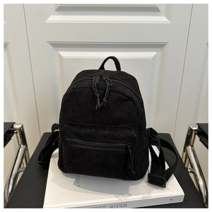 Nahaufnahme eines schwarzen Cord-Rucksacks mit Fronttasche und verstellbaren Trägern