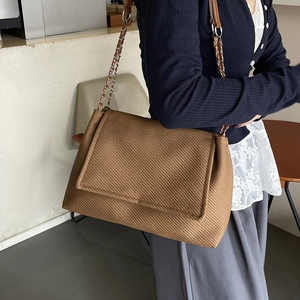 Sac à bandoulière tressé marron avec bandoulière chaîne et rabat au style chic