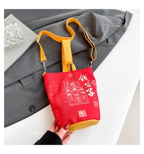 Detail of red canvas lucky money bag with gold straps and Chinese God of Wealth print
