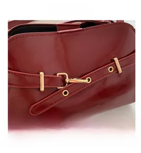 Nahaufnahme der roten Hochglanz-Muscheltasche mit goldener Schnalle und PU-Ledertextur