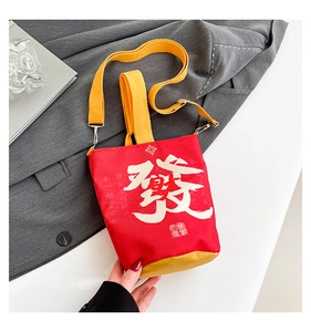 Detail of red canvas money bag with white character and yellow contrasting strap