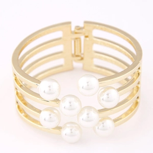 Détail d'un bracelet manchette doré multicouche avec sept perles et charnière robuste