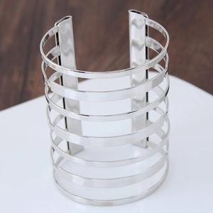 Chic wide multi-layered silver cuff bracelet with high-polish finish on a display stand