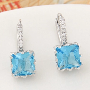 Detail of silver leverback earrings featuring a square blue zircon and pavé crystals