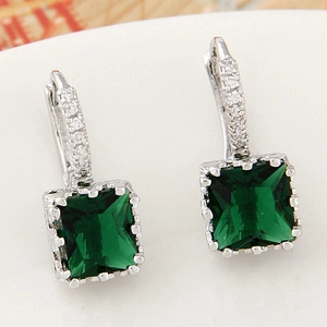 Detailed macro view of square emerald zircon earrings with silver crystal paved hooks