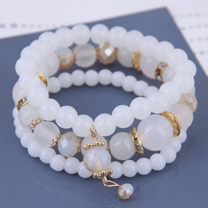 Detailed view of bohemian triple-layered beaded bracelet with elephant and tassel charms