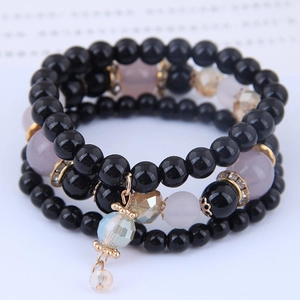 Macro detail of triple-layer beaded bracelet with crystal charms and metallic spacers