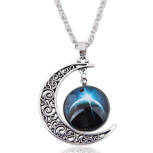 Detail of silver crescent moon necklace with vintage engraving and celestial star pendant