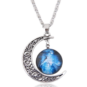 Detailed shot of hollow silver moon pendant with blue nebula glass ball and chain