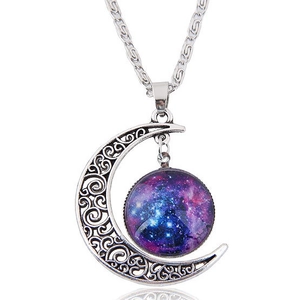 Macro detail of vintage hollow silver moon pendant with celestial starry galaxy glass cabochon