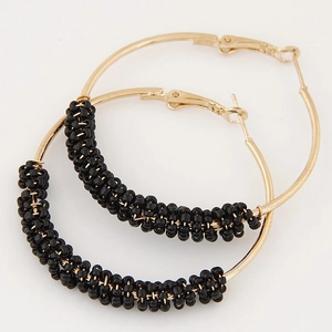 Golden metal hoop earrings with black seed beads and a bohemian minimalist design