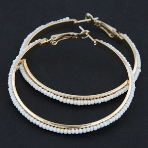 Fashionable large gold-toned beaded hoop earrings with white seed beads in boho style