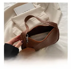 Interior capacity view of brown woven leather bag with detachable round coin purse