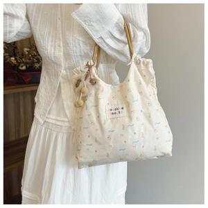 Détail d'un sac cabas en nylon avec imprimés d'animaux et poignée en cordelette