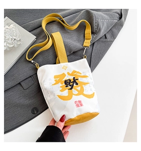 Detail of canvas bag with yellow 'Fa' character print and dual shoulder straps