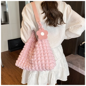 Détail du sac à main rose texture bulle avec pendentif fleur et bandoulière en cuir