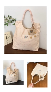 Detail of pink canvas tote with rabbit prints and plush lion charm for daily use