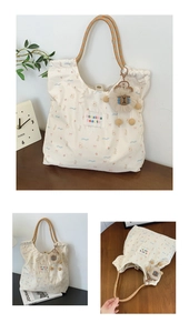 Floral canvas tote with orange woven handles and plush charm on a wooden desk