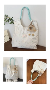 Close-up of floral canvas tote bag with woven handles and cute plush charm pendant