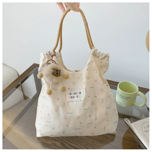 Détail du sac cabas en toile avec motifs d'animaux et poignées tissées à damier