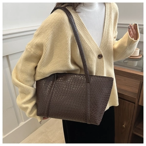 Dettaglio della trama intrecciata marrone scuro e manici di una borsa tote
