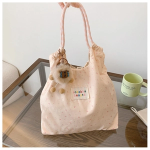 Détail du sac en toile rose à fleurs avec motif lapin et porte-clés en peluche doux