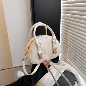 Dettaglio mini borsa bowling bianco crema con fibbie dorate e doppi manici
