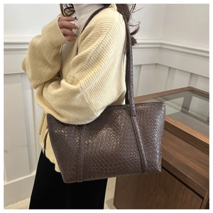Dettaglio della trama intrecciata a mano su una grande borsa tote in pelle marrone
