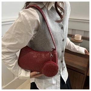 Detail of burgundy woven hobo shoulder bag with matching round coin purse charm