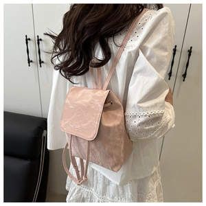 Gros plan d'un mini sac à dos rose avec texture marbrée porté dans un cadre moderne