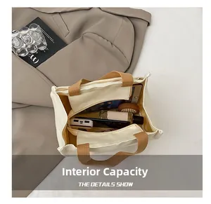 Vue intérieure du sac cabas en toile montrant le compartiment principal et la poche zippée