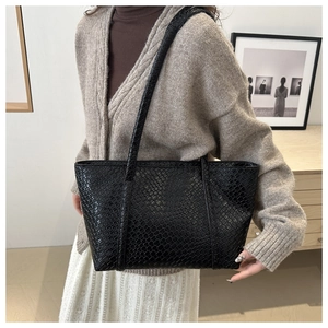 Dettaglio della trama intrecciata e dei doppi cinturini su questa borsa tote nera