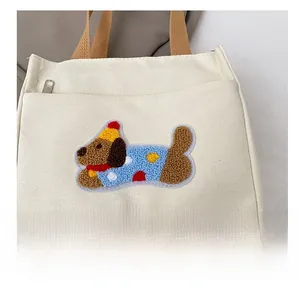 Détail de la broderie bouclée teckel sur sac en toile beige avec inscription MISSYOU