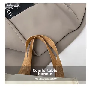 Détail des poignées tissées durables sur un sac cabas en toile minimaliste au fini beige doux