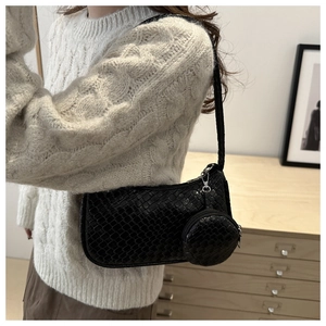 Close-up of black woven hobo bag texture with a matching small round coin purse charm
