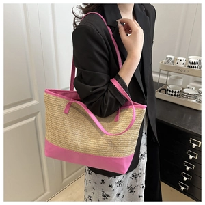 Detalle del bolso tote de paja con ribete de cuero rosa vibrante y asas dobles