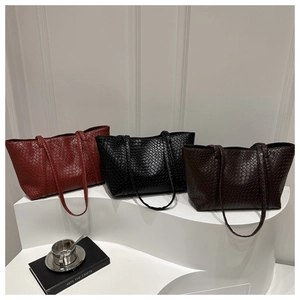 Detailed view of woven texture on minimalist tote bags in red, black and brown