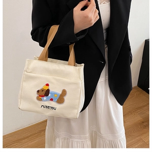 Détail de la broderie chien et du texte MISSYOU sur un sac cabas en toile avec anses brunes