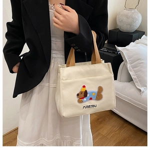 Détail de la broderie teckel et du texte MISS YOU sur le sac à main en toile crème